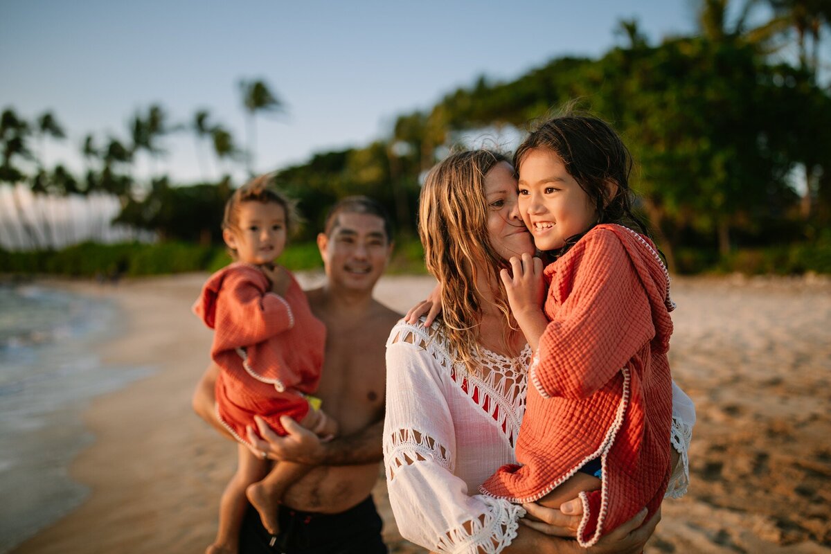 family of four snuggles at sunset  at kihei beach