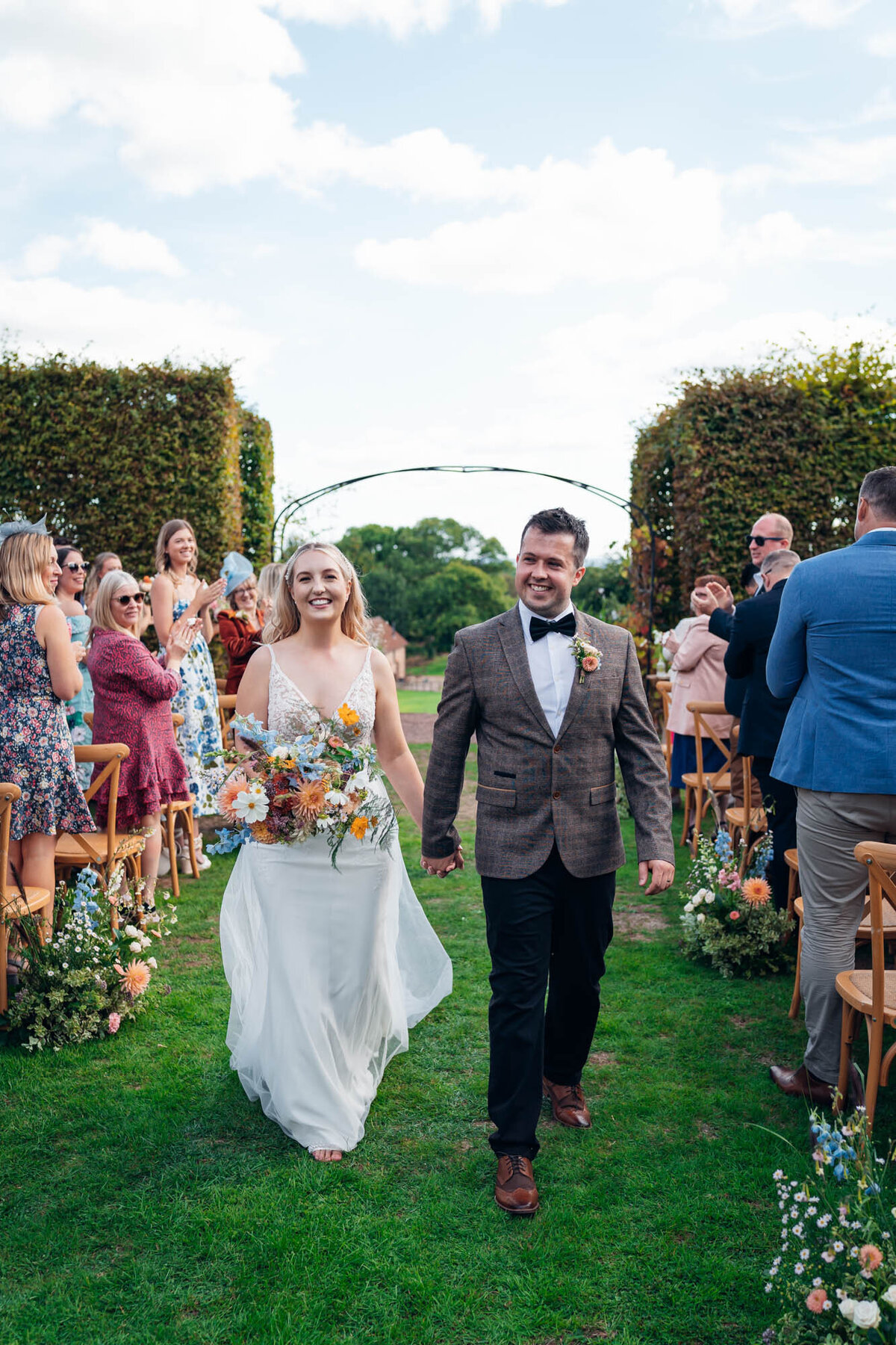 cheltenham-wedding-photographer- newlyweds-exiting-wedding-ceremony