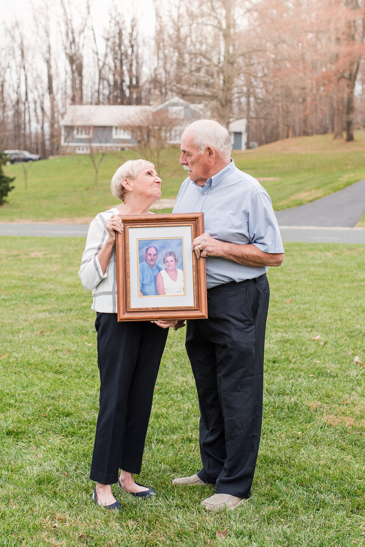 senior couple holding vintage photo of themselves