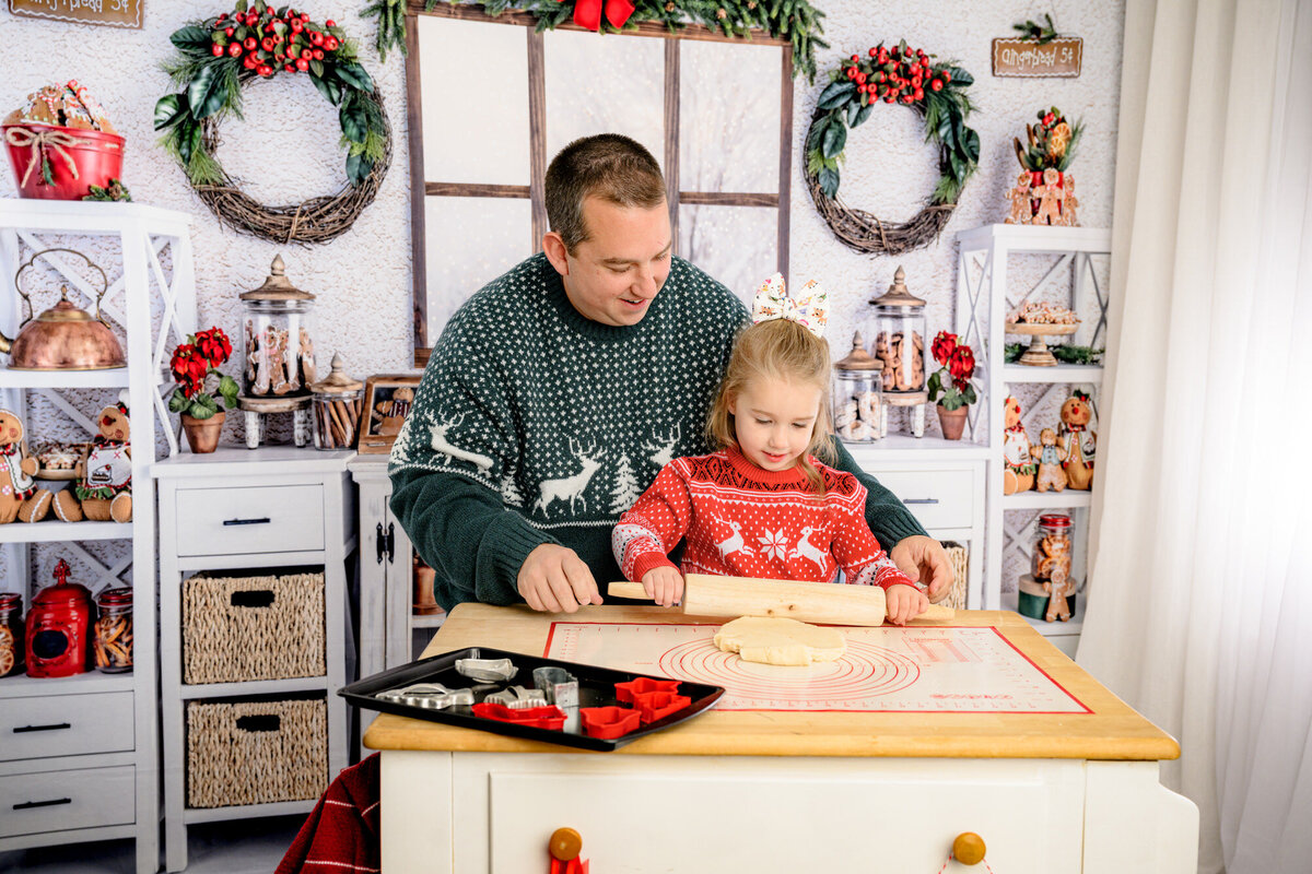 father helps daughter making cookies durin gholiday mini session