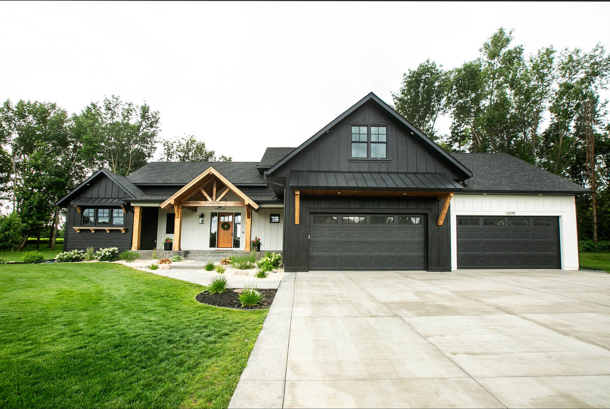 Custom Minnesota Home built by Cornerstone Custom Builds with black and white siding, wood accents and modern finishes.