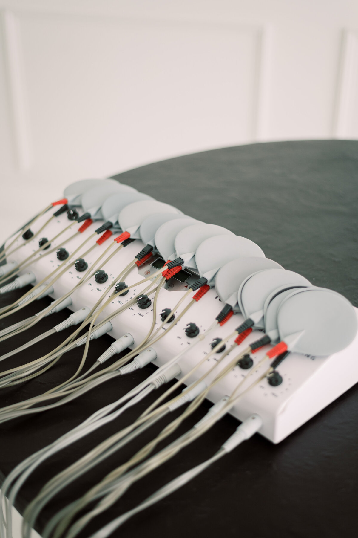 Modern black round table with medical aesthetic equipment for body contouring
