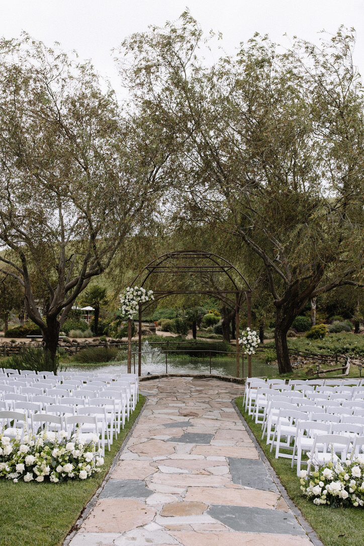 Left corner and right tieback, wedding altar, arch, beginning of aisle arrangements, white and green flowers