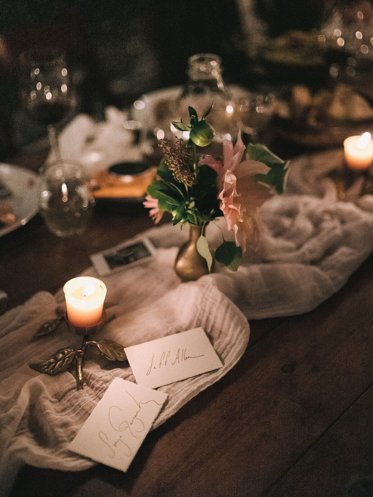 A beautiful dining table with flowers, candles, and name cards in Foxfire Mountain House, New York. Wedding Image by Jenny Fu Studio