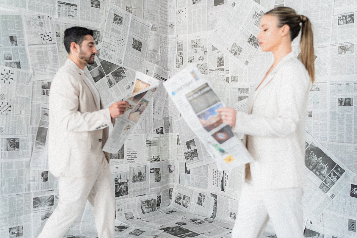 A couple walks with newspapers