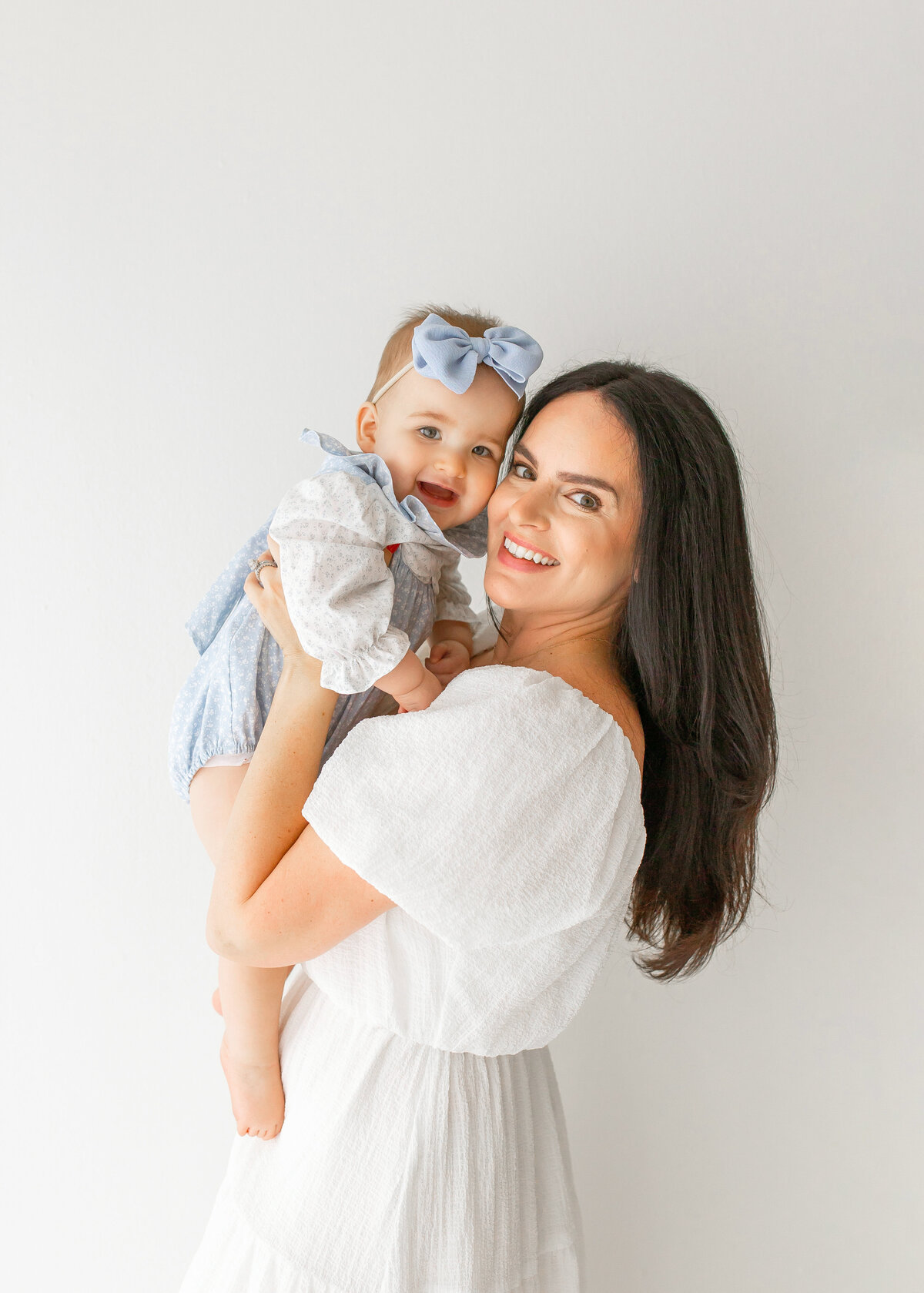 mom holding baby girl to her face