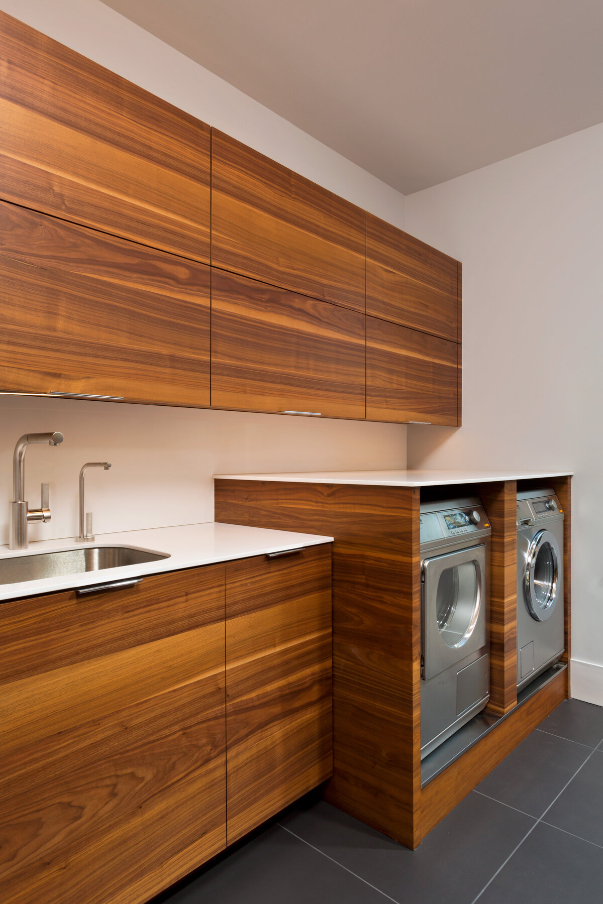dark wood cabinet laundry room against white walls