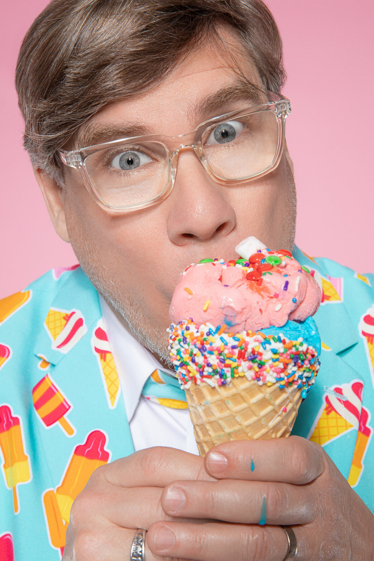 A man eating a colorful ice cream cone