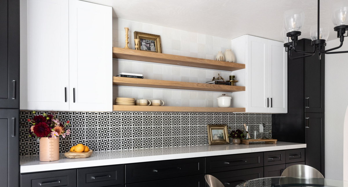 Luxury black and white kitchen with floating shelves and designer tile backsplash.