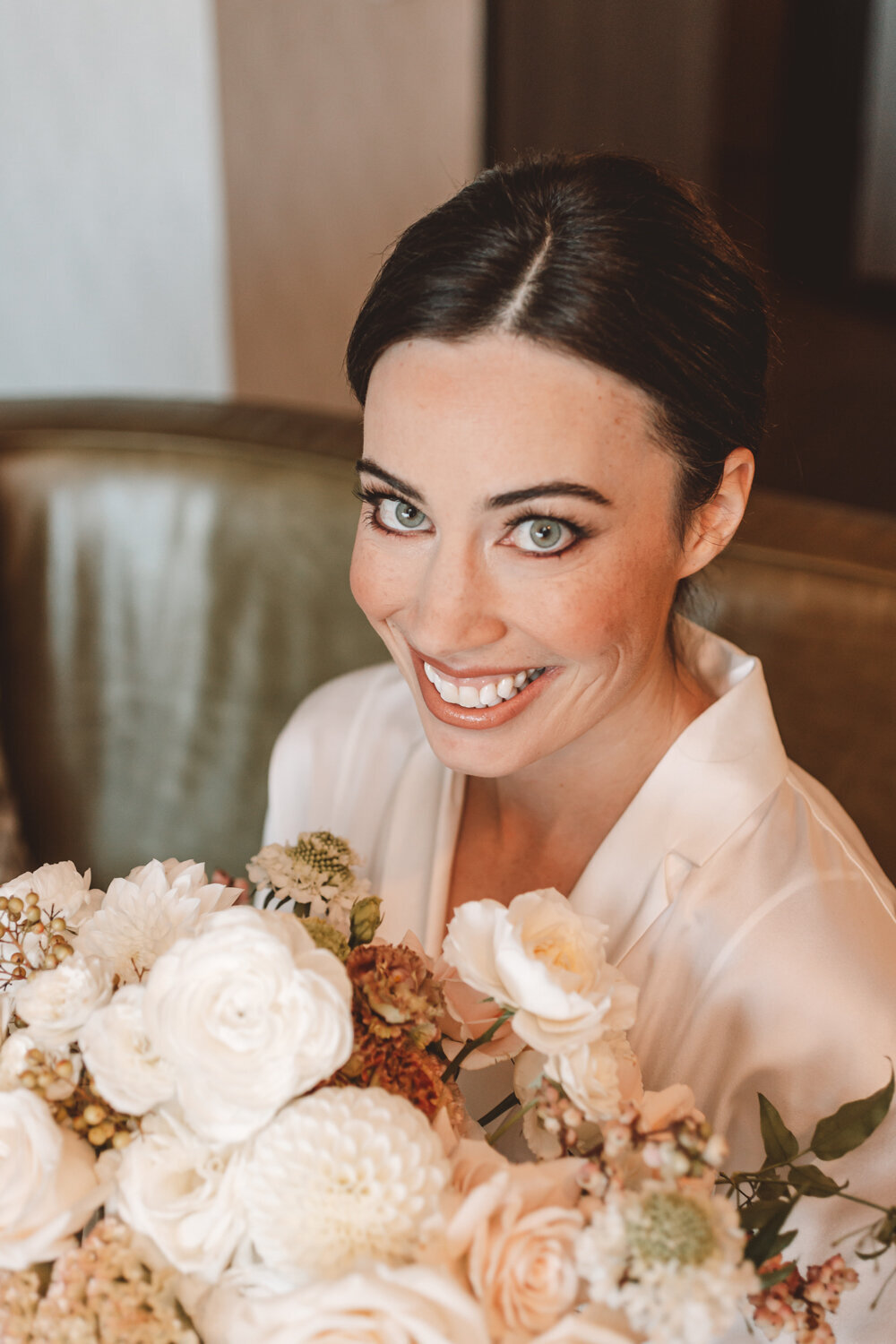 Bridal portrait at Kimpton Armory in Bozeman, MT, highlighting the bride's makeup and soft blush floral bouquet.