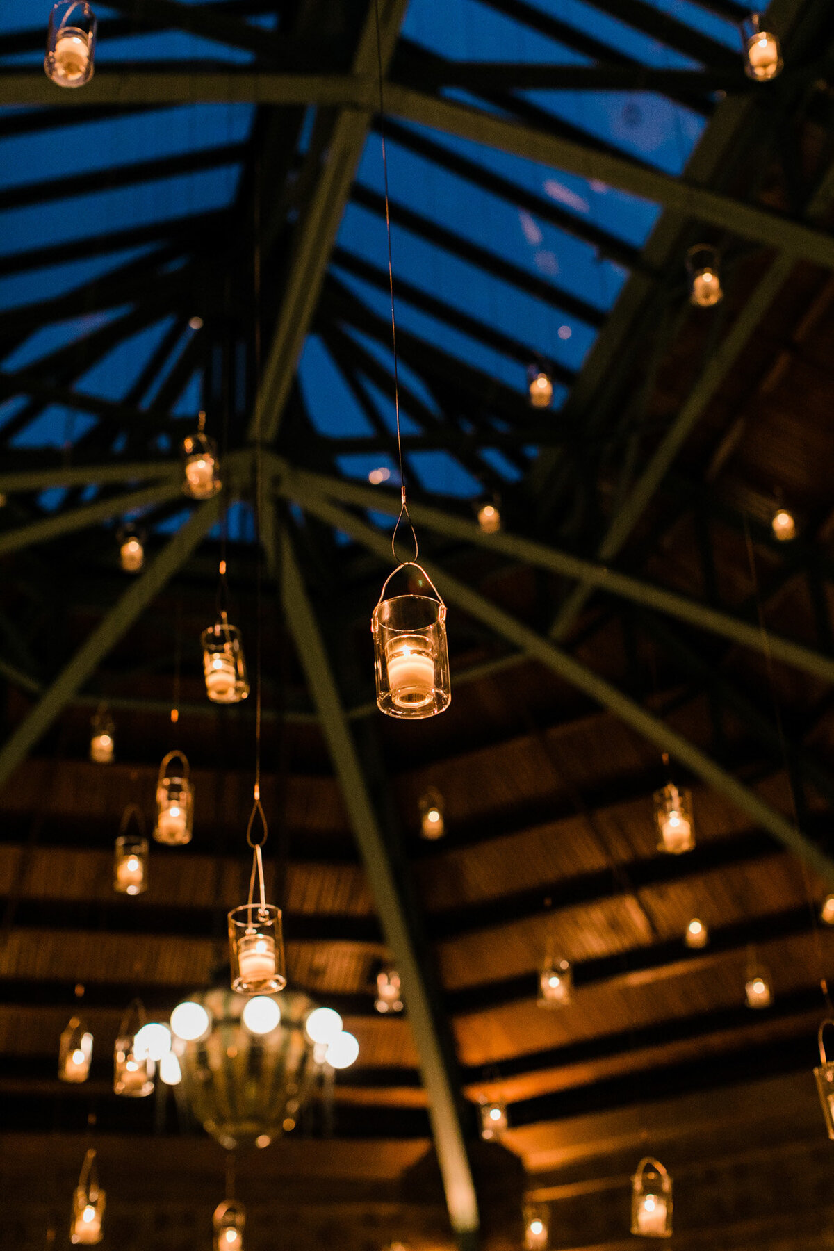 Beautiful candles are suspended from the ceiling at Cafe Brauer for a wedding reception