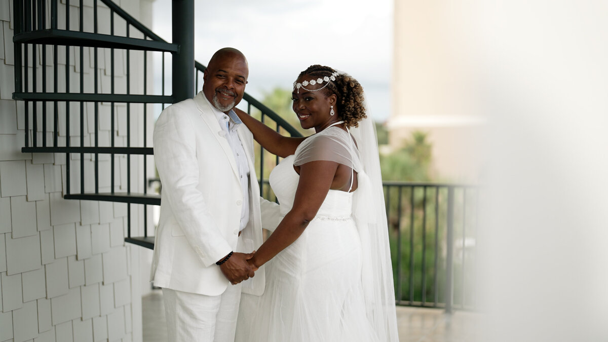Couple pose by a staircase for their destination wedding in Destin fl.