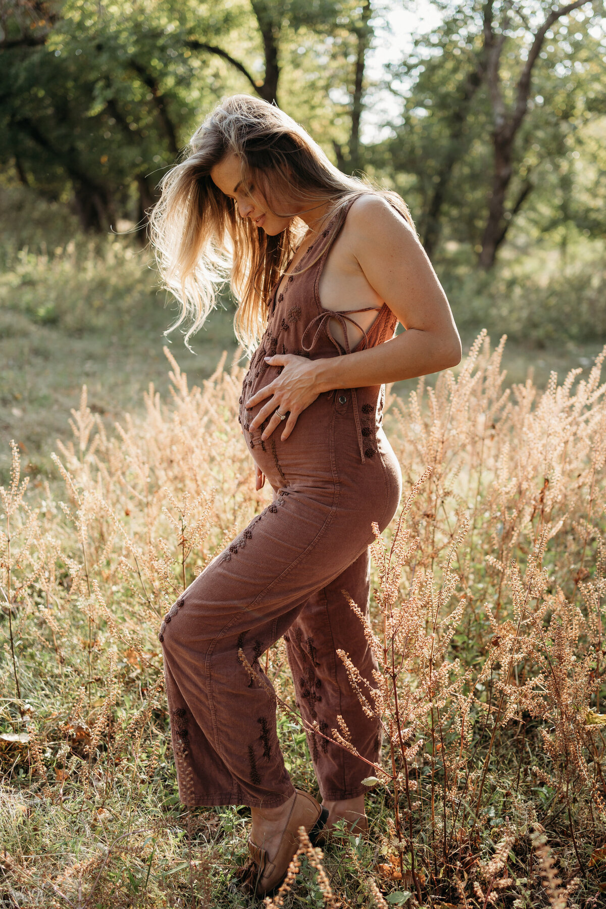 Mom to be holding pregnant belly in field in BIrmingham, AL.