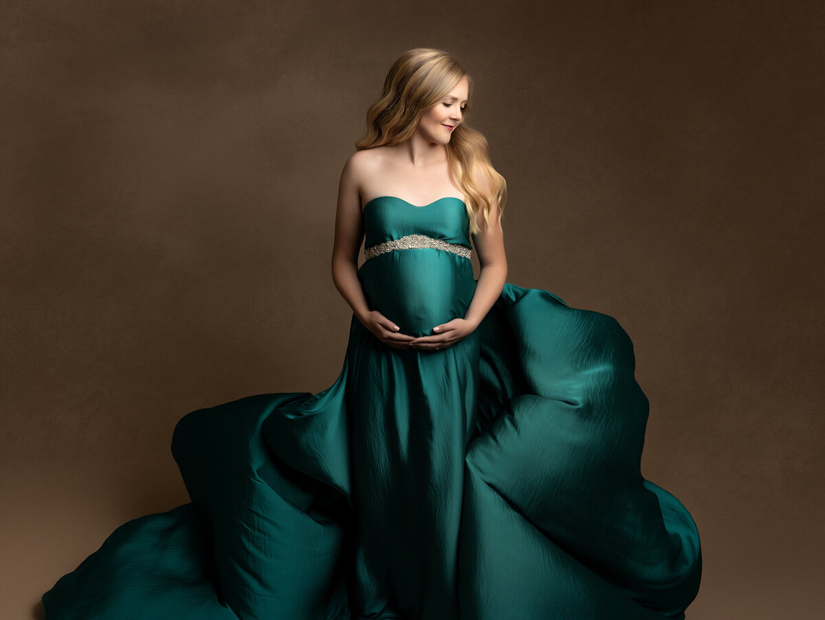 Expecting mother with teal flying fabric gown charleston sc maternity