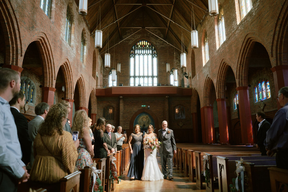 Bride walks up the aisle at Blessed Sacrament Catholic Church.
