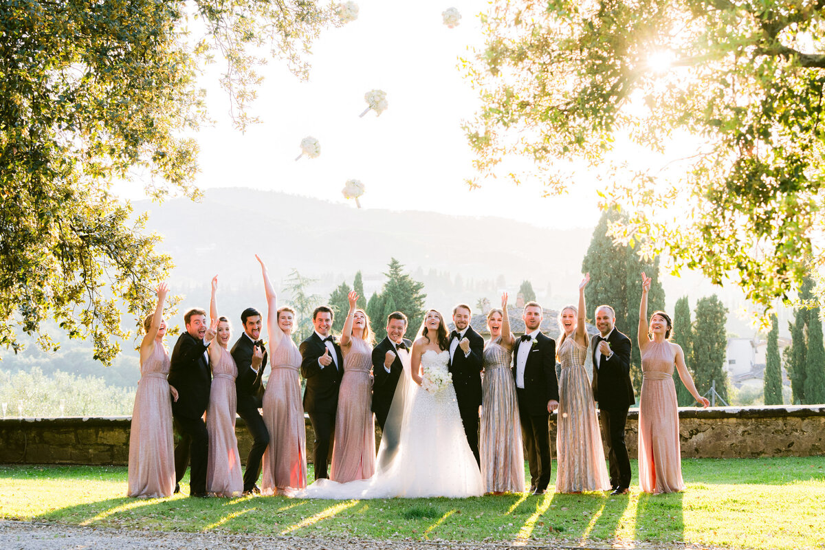 a fun bridal party photo on the wedding day throwing the bouquets