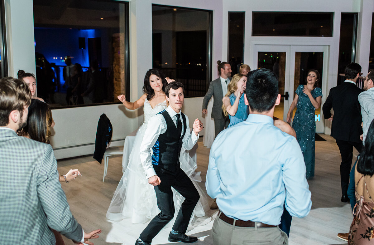 Bride and groom dance with their guests at their wedding reception at The Oaks