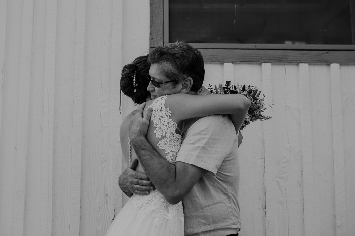 A person hugging someone in a wedding dress