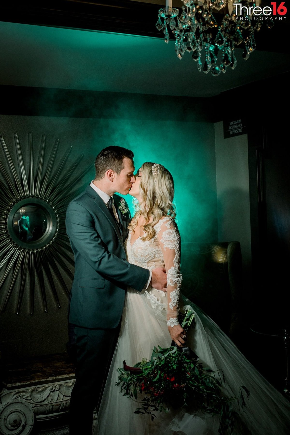 Bride and Groom share a kiss with a green glow behind them