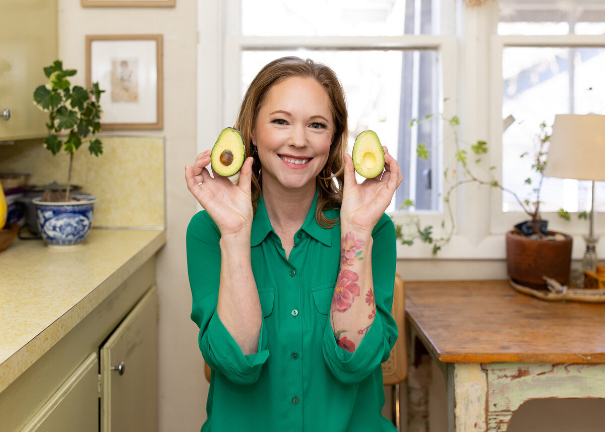 Photo of female holding avocados in a Portland Oregon kitchen. 