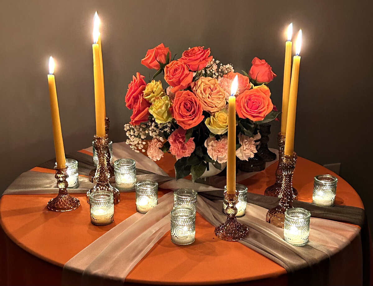 Vibrant orange tablescape featuring lush orange and yellow florals, creating a warm and inviting event setting, designed by In Full Bloom Event Planning & Design