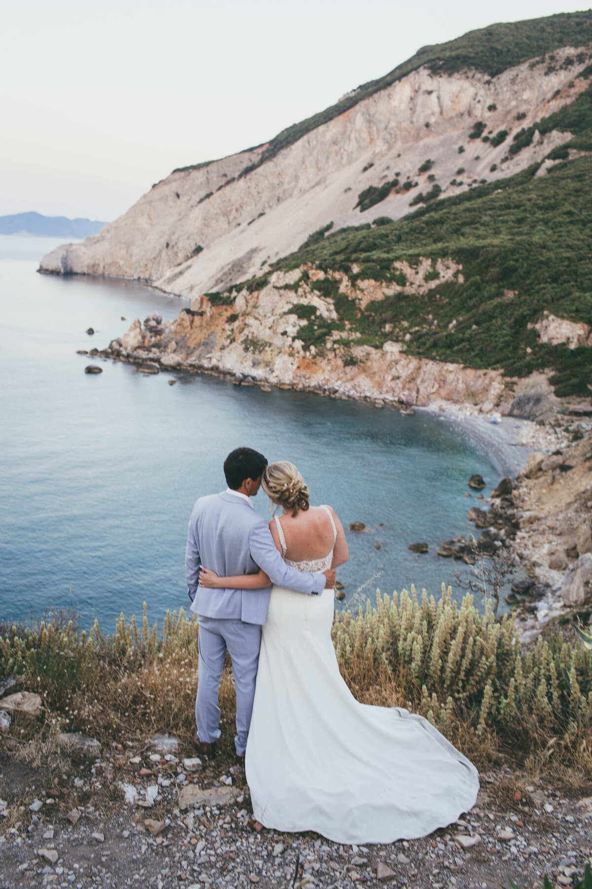 bride and groom looking out over ocean