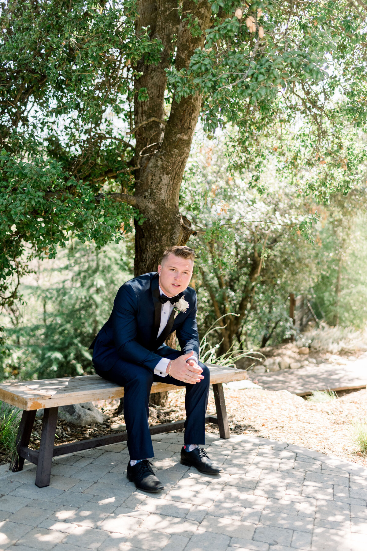 Groom portrait sitting down in  a bench