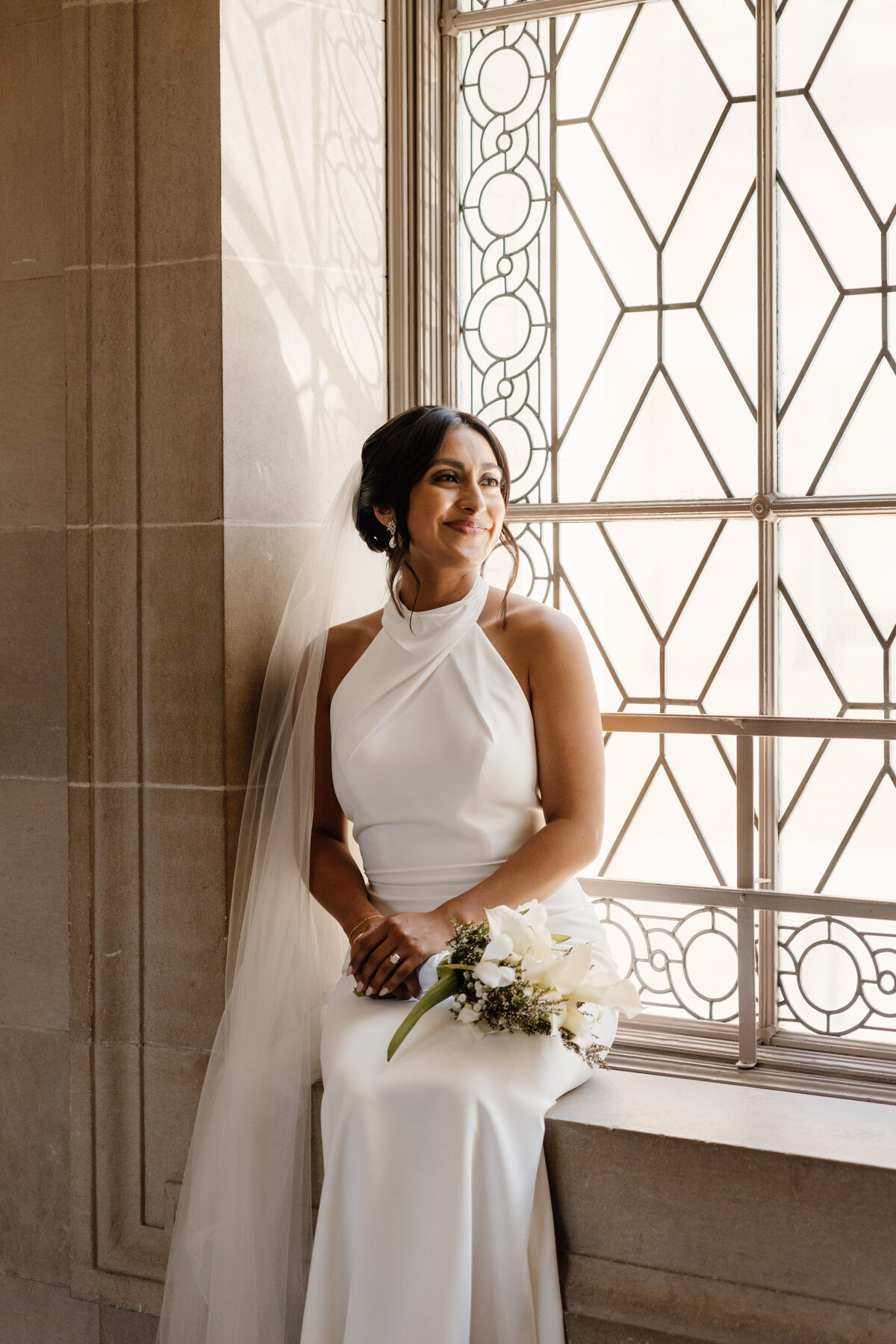 bride sitting in san francisco city hall on wedding day
