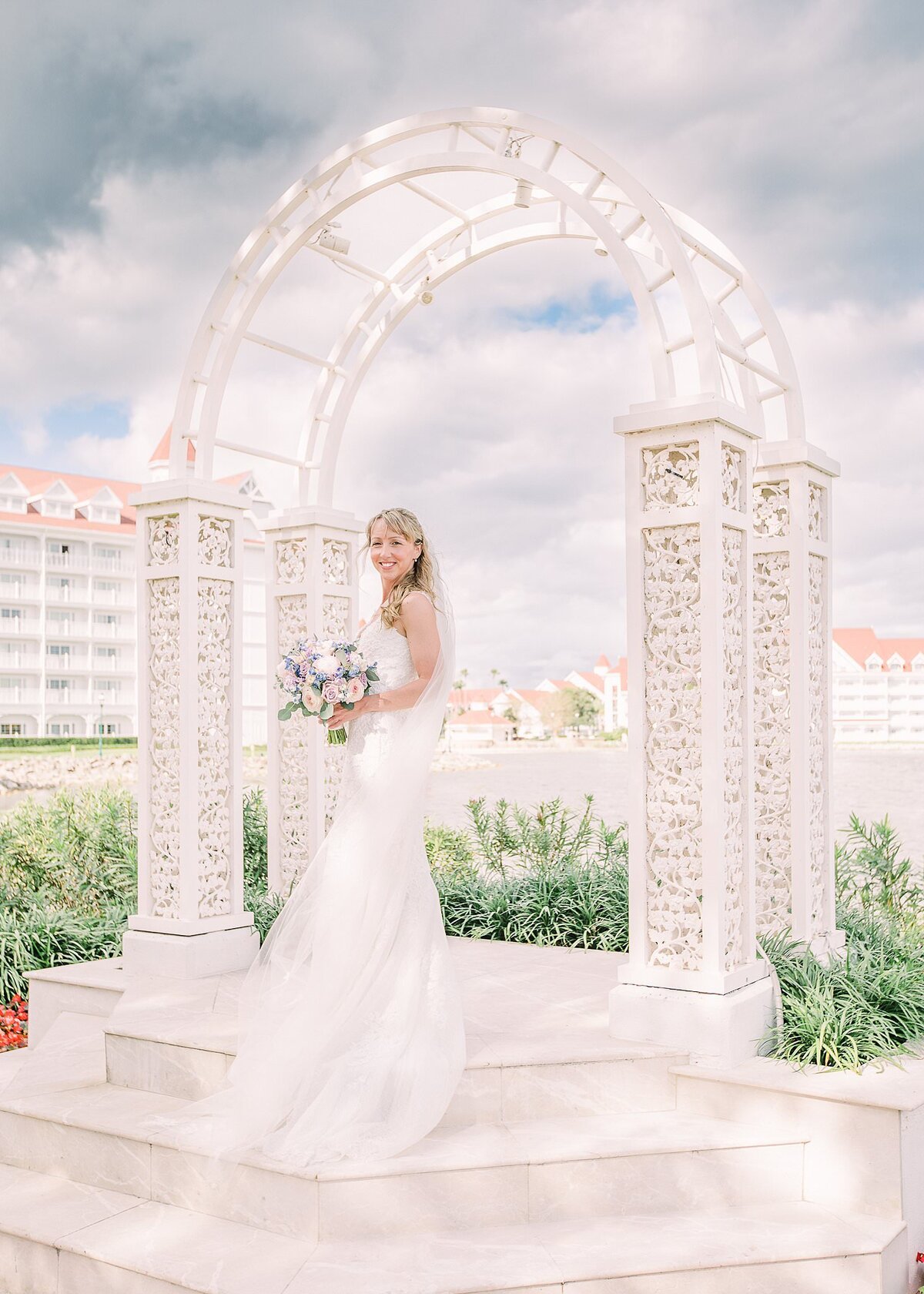 Bride posing by arch at Disney Wedding Pavilion