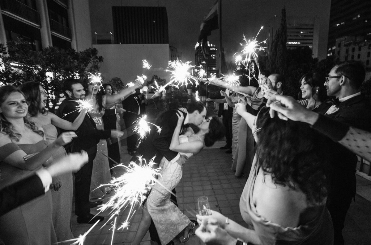 rooftop-downtown-sparkler-exit-wedding-kiss