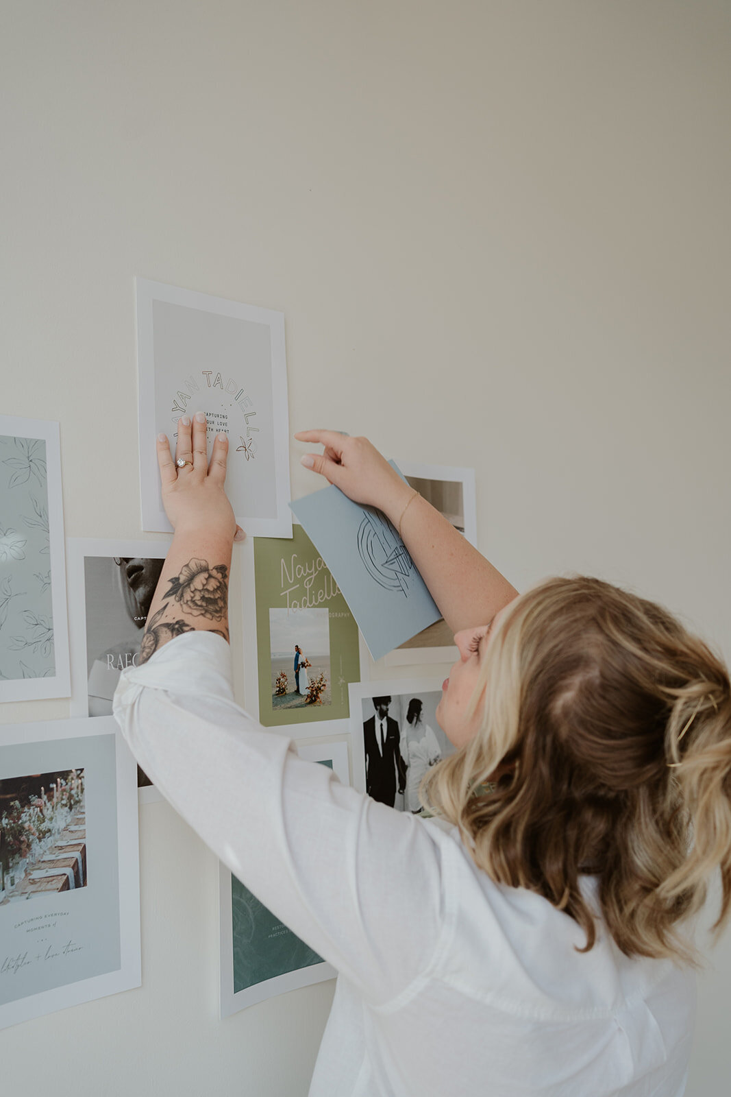 Photo of a woman arranging prints and artwork on a mood board during a Kalamazoo Michigan Wildher and Co branding shoot.