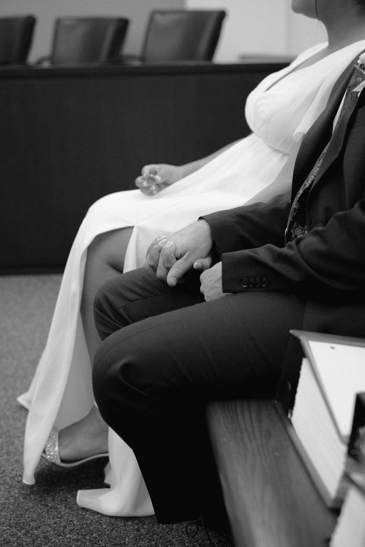 couple sitting and holding hands at the courthouse