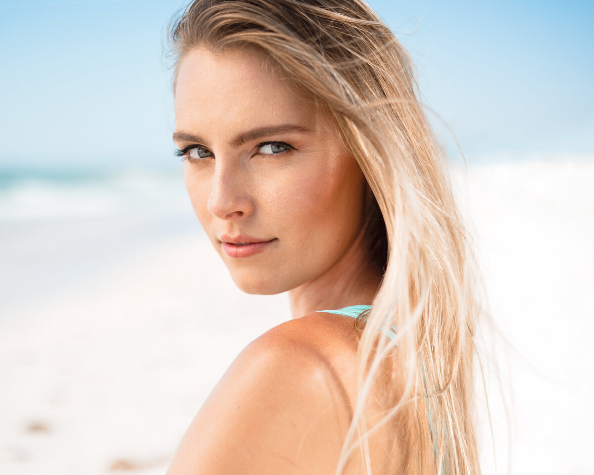 Model looks back at camera while wearing blue bikini