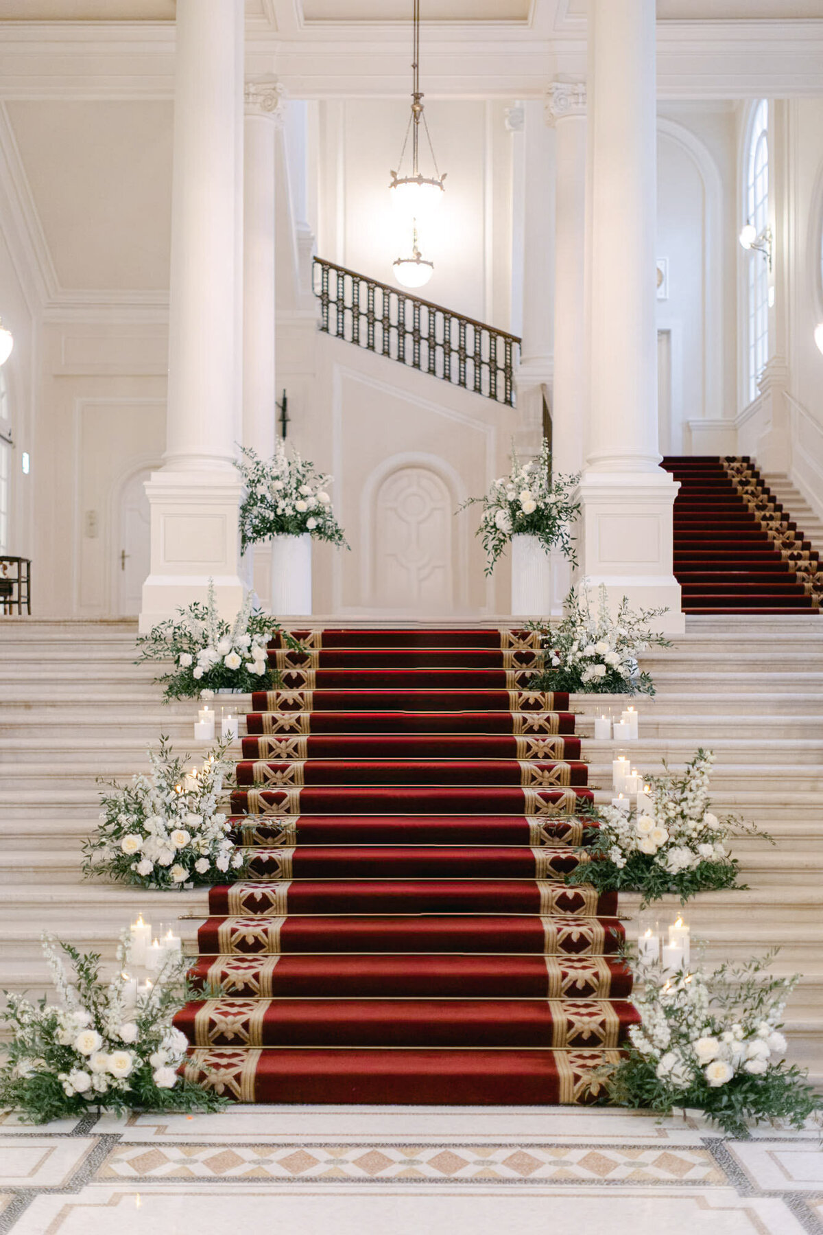 Grand staircase decorated with fresh flowers and candles on the side for a destination wedding in Vienna