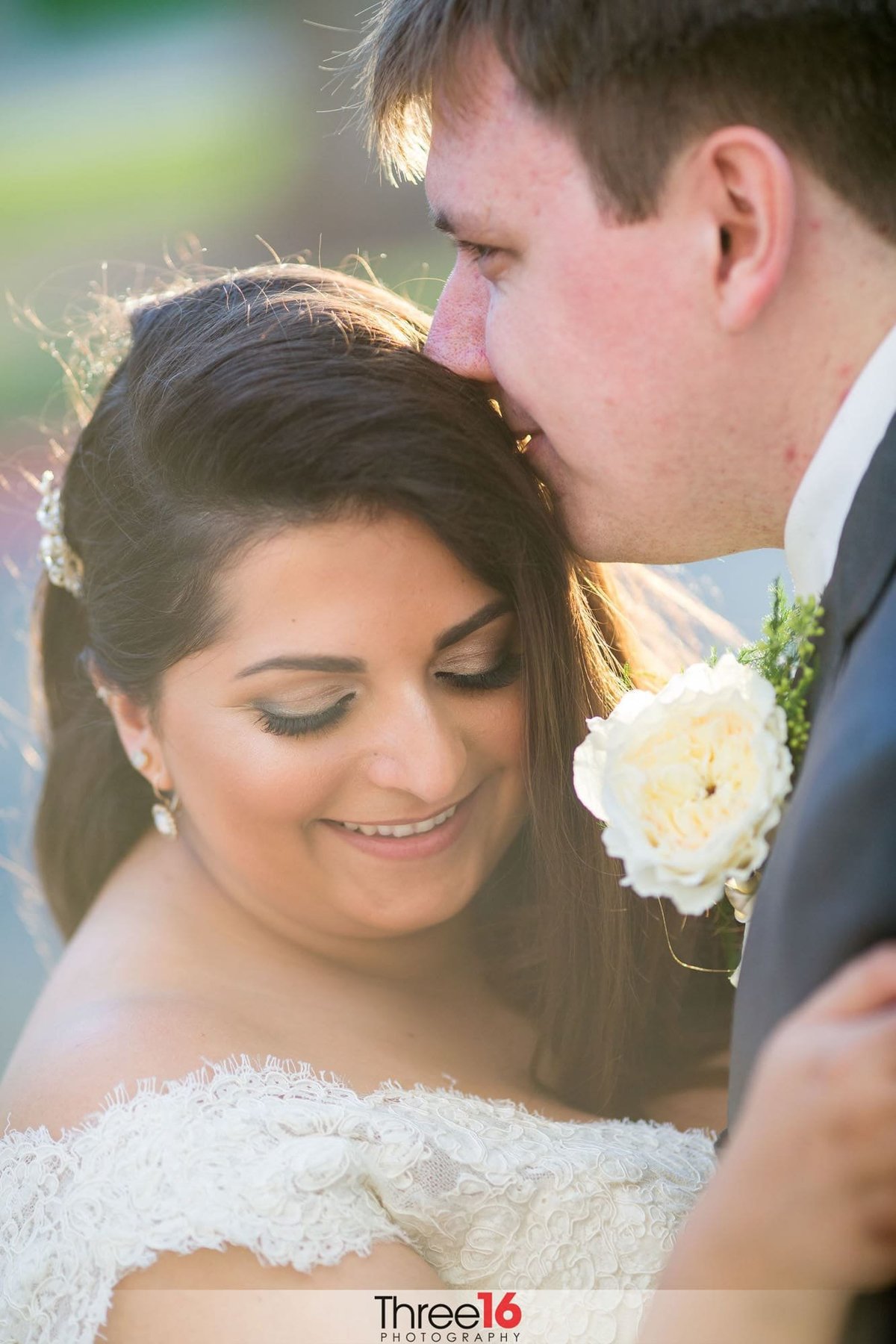 Groom kisses his Bride's head in a tender moment