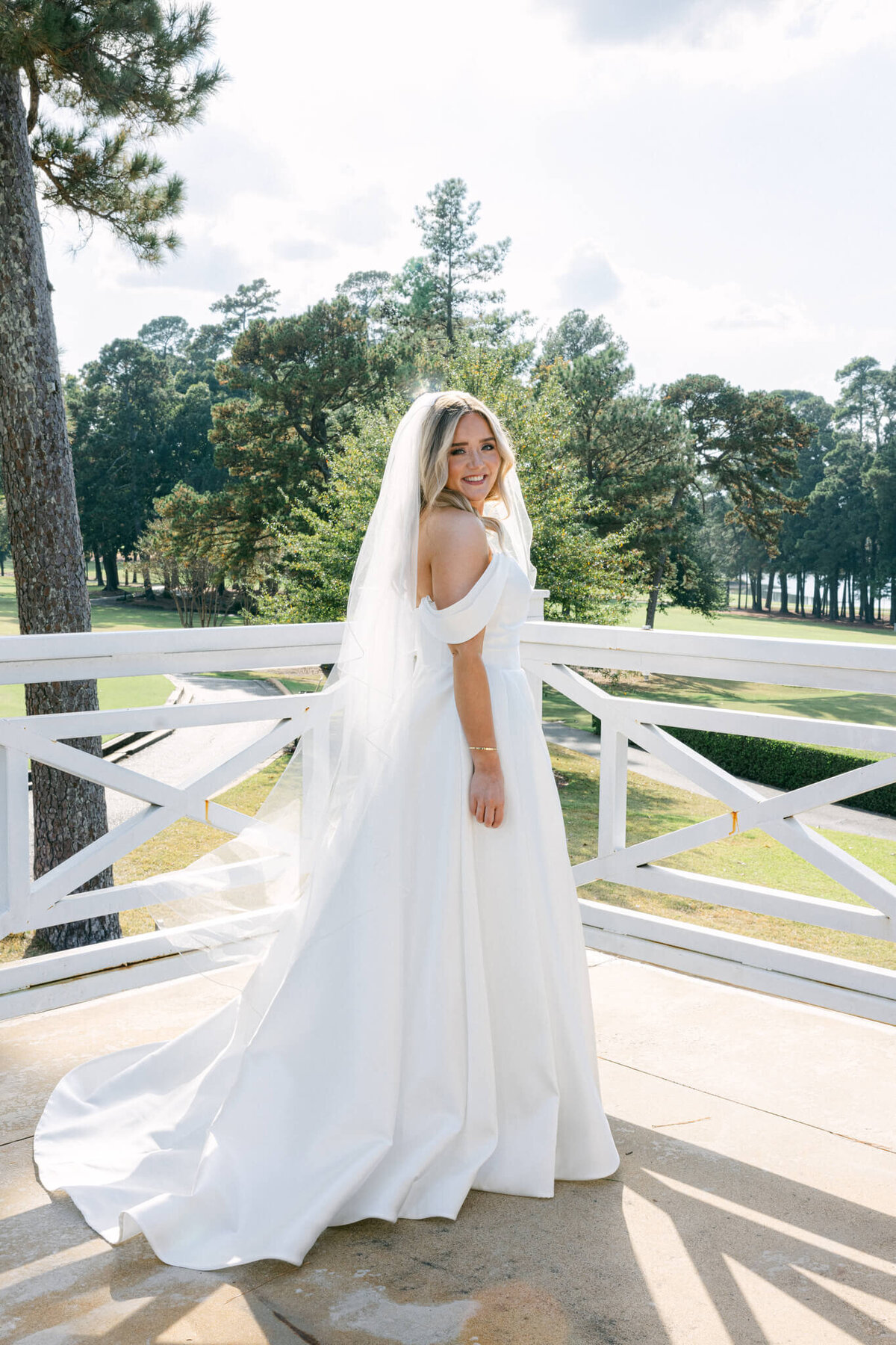 A wedding day photo of the bride in her white wedding dress posing for a portrait