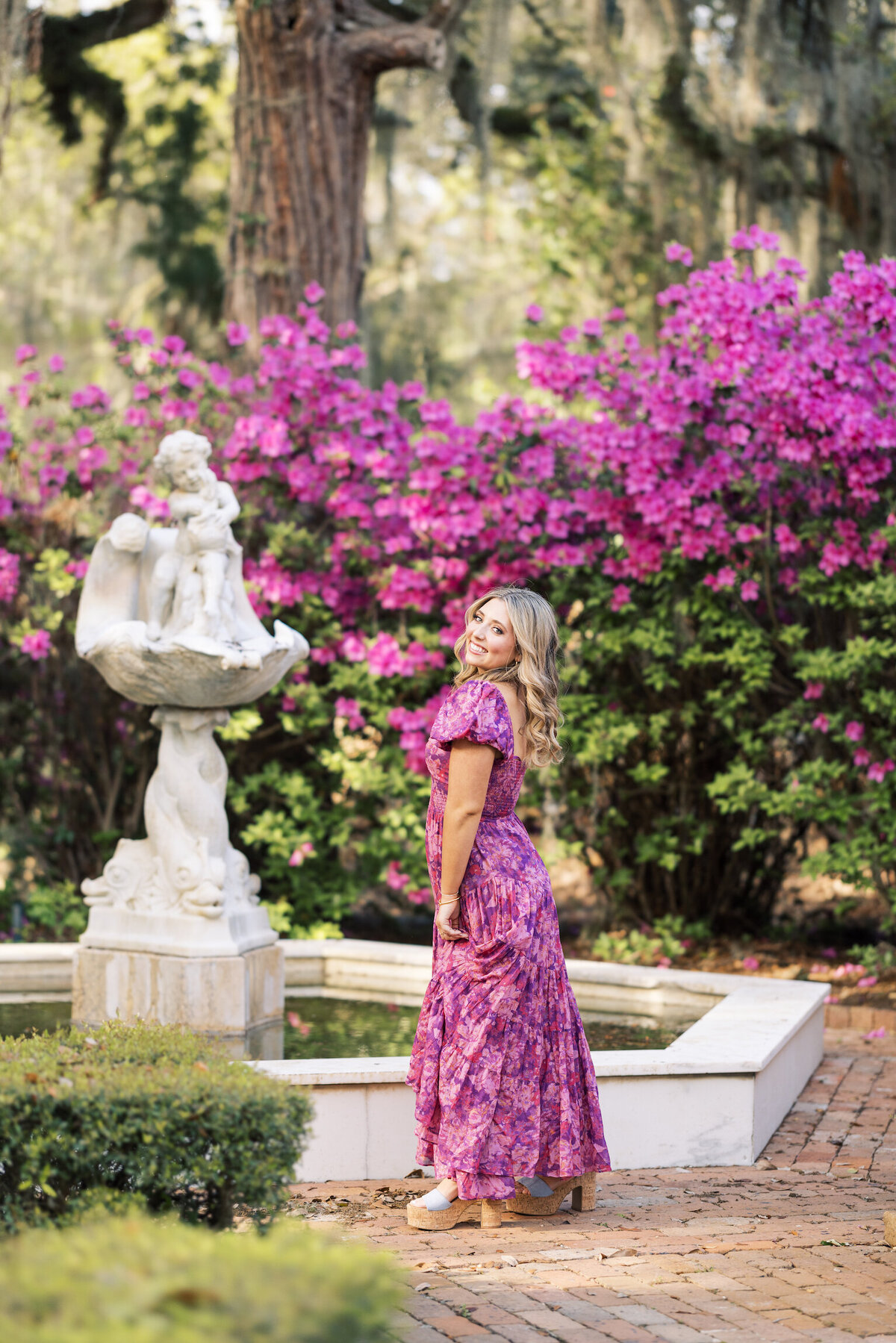 A senior portrait in the lush gardens of Rosedown Plantation, showcasing charm and elegance amid beautiful blooms, captured on film by Morgan Alysse, Louisiana film photographer.