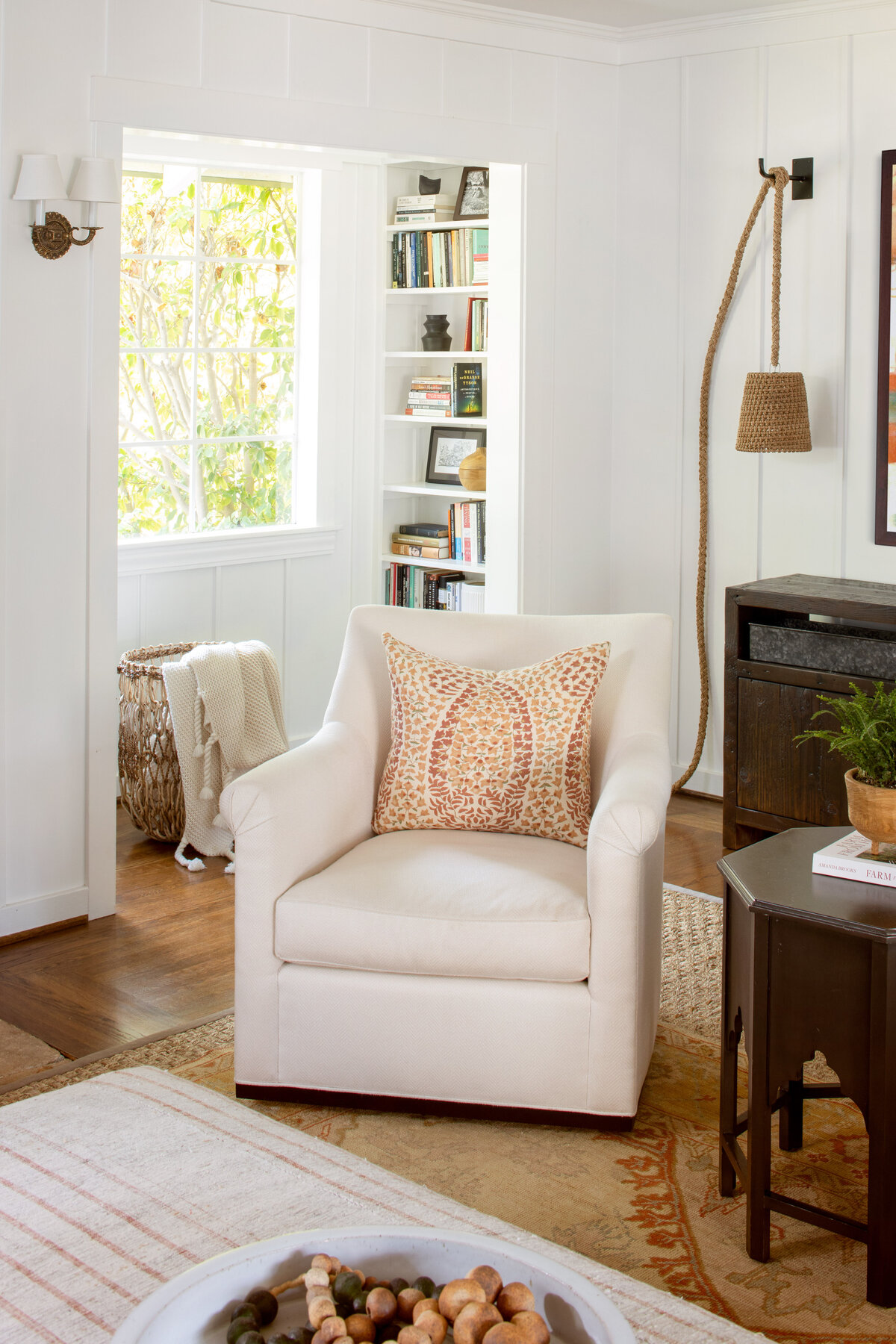 Cozy living room with a comfortable armchair and bookshelves, showcased in interior photography