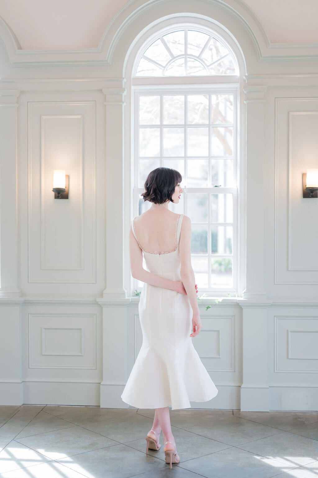 The midi-length fit-and-flare silhouette of the Lana style is a sassy yet sophisticated vibe for a little white wedding dress.
