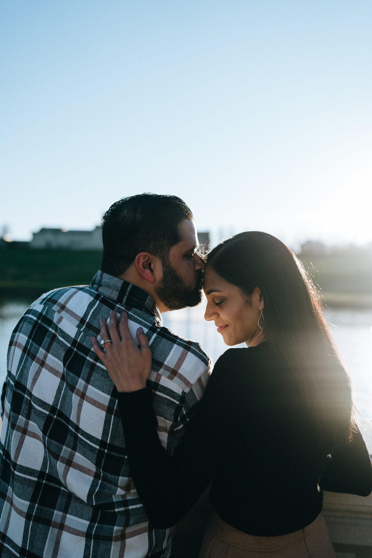man kissing fiancee on forehead