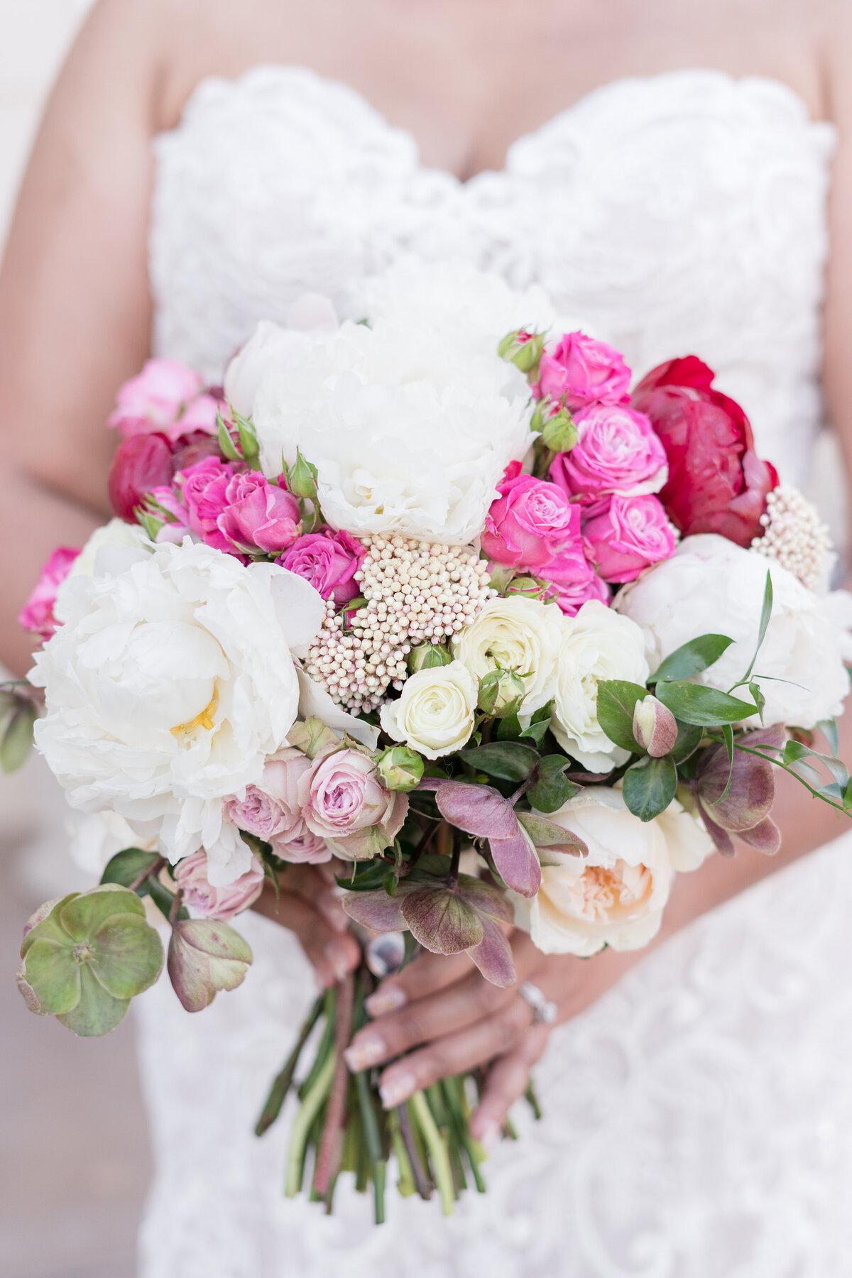 red, white, pink and cream bridal bouquet held by bride