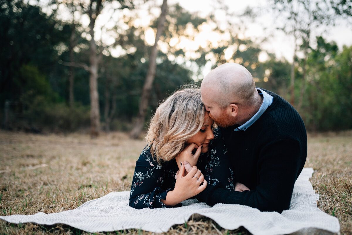 Man and woman snuggling, lying down on picnic rug .Couples photography Melbourne, And So I Don’t Forget Photography