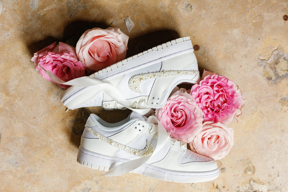 White wedding sneakers adorned with pink flowers and delicate bridal accessories for Victoria’s Cartagena Colombia wedding.