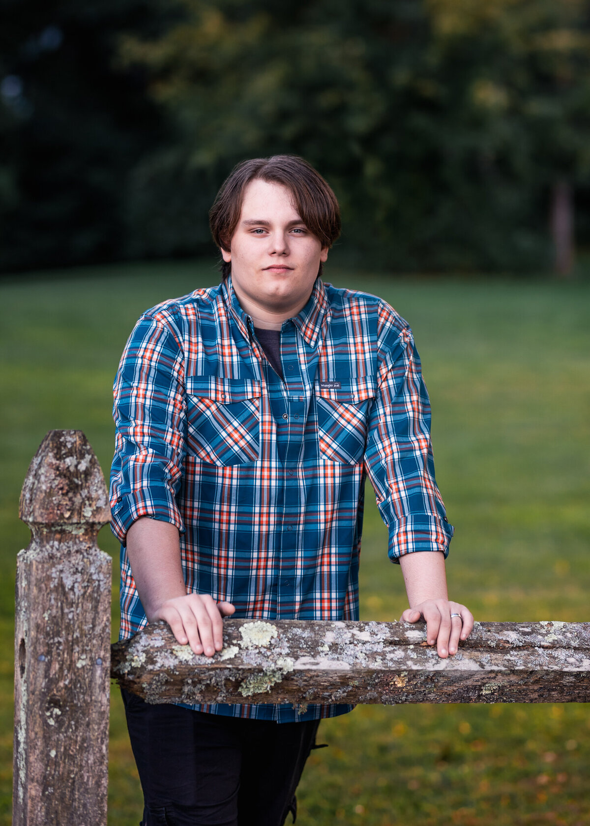 High School Senior Posing for photo behind a fence in greely park in nashua nh by lisa smith photography