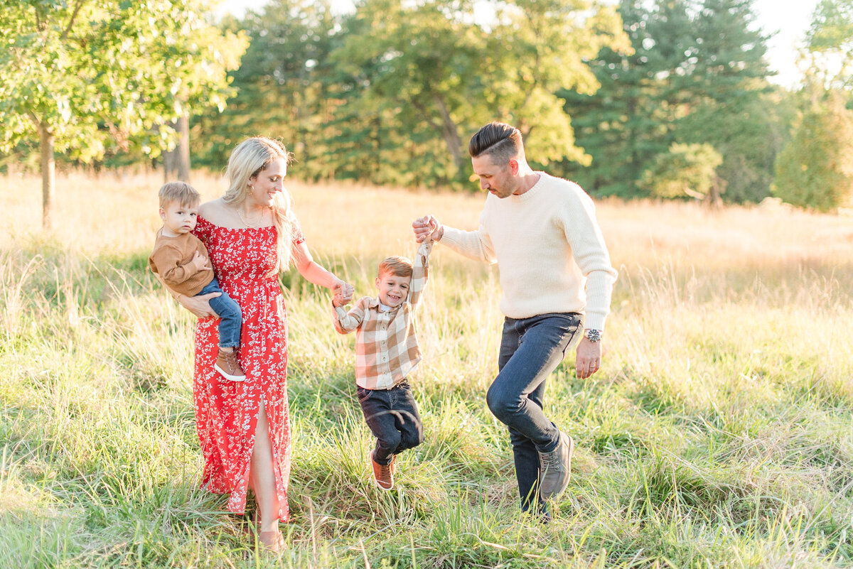 family having fund in field red dress neutral outfits