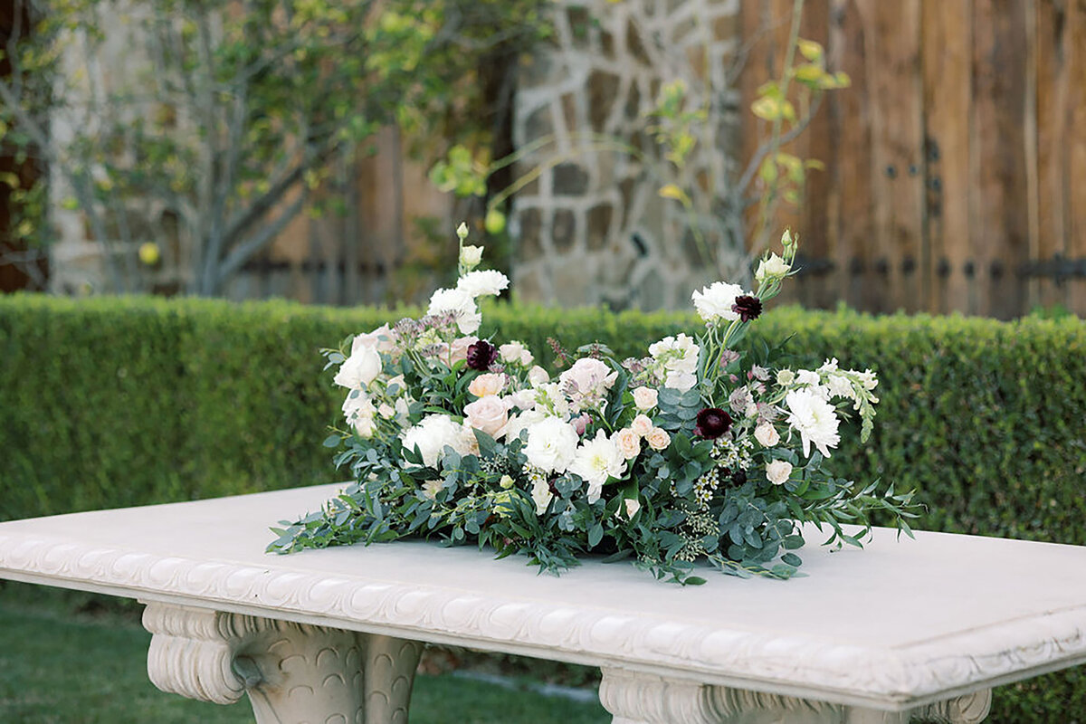 Cascading Greenery and Burgundy Ranunculus