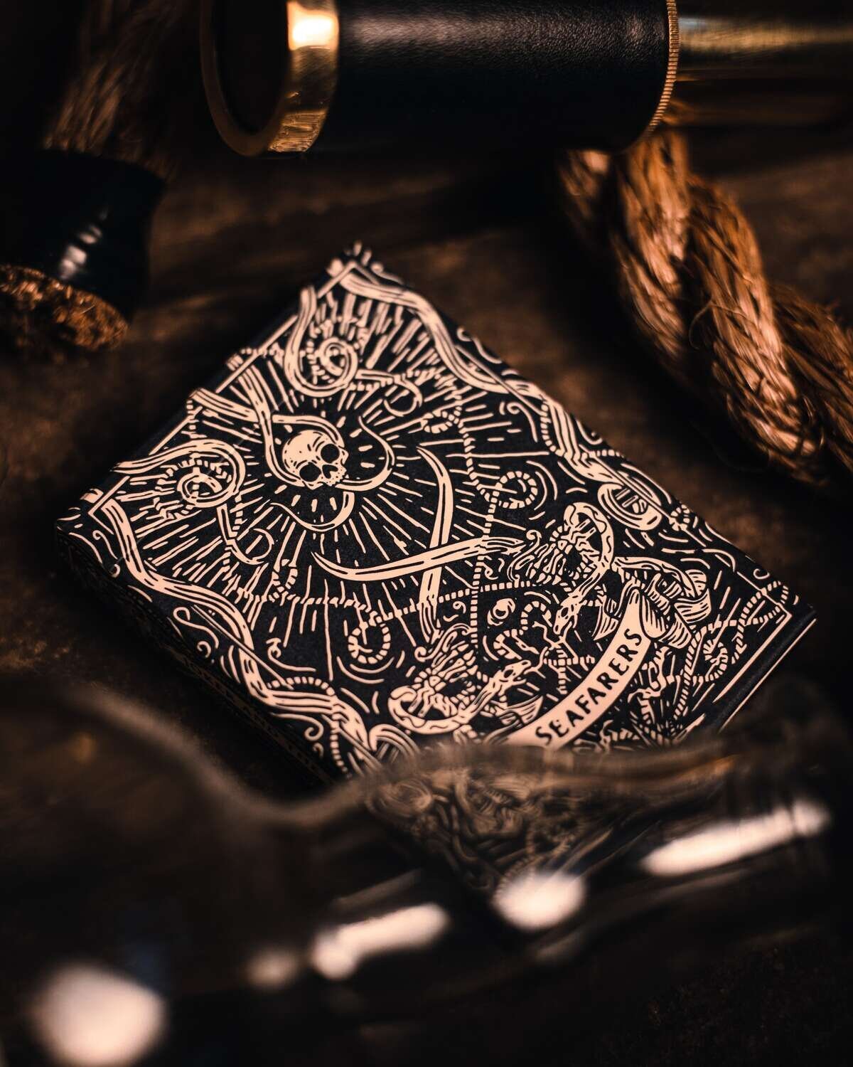 Seafarers playing card amongst glass bottle and rope