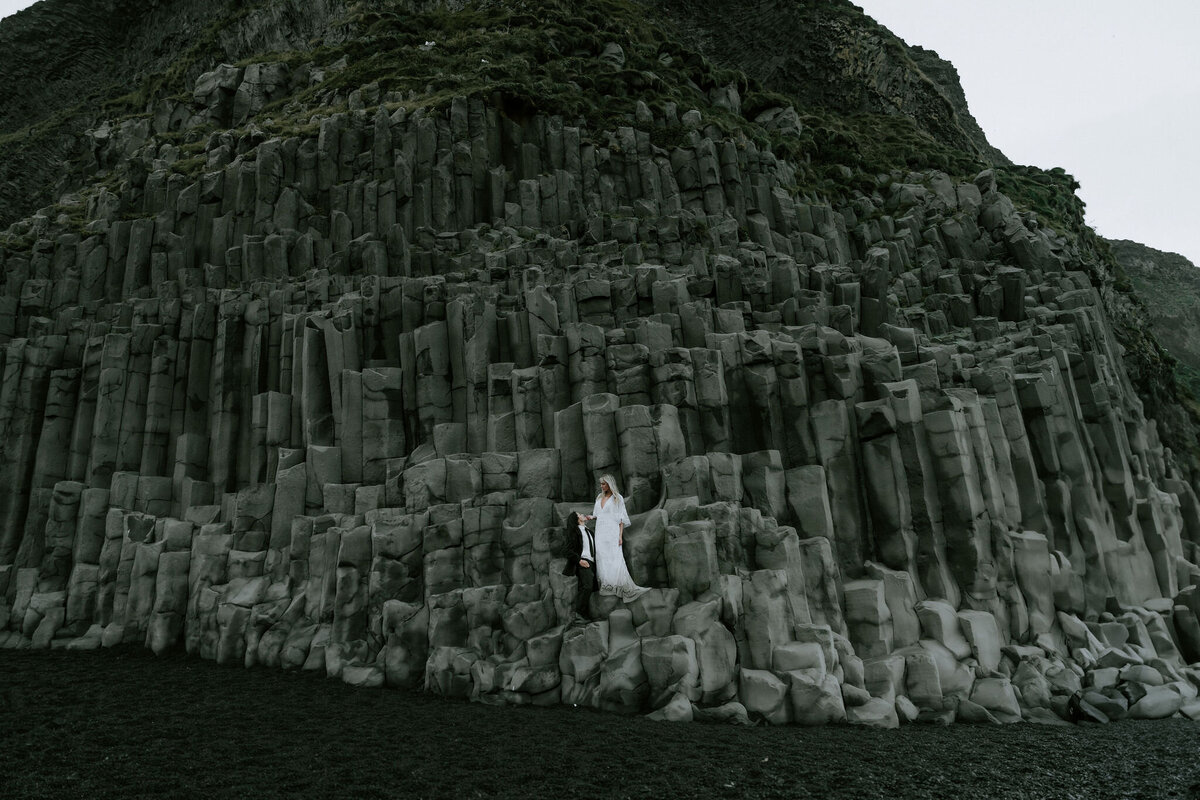 Reynesfjara eloping couple in iceland posing on famous rocks