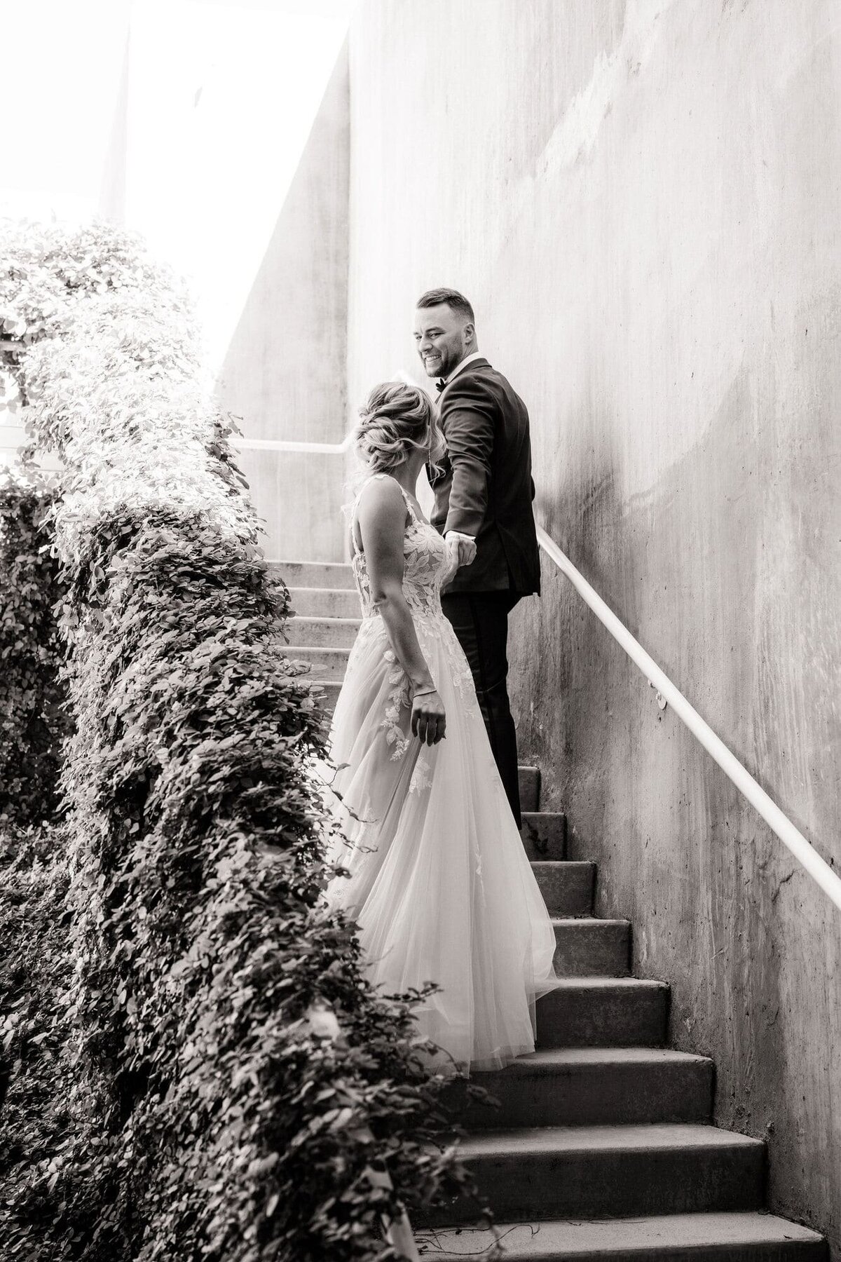 Bride and groom walking past each other on the stairs.