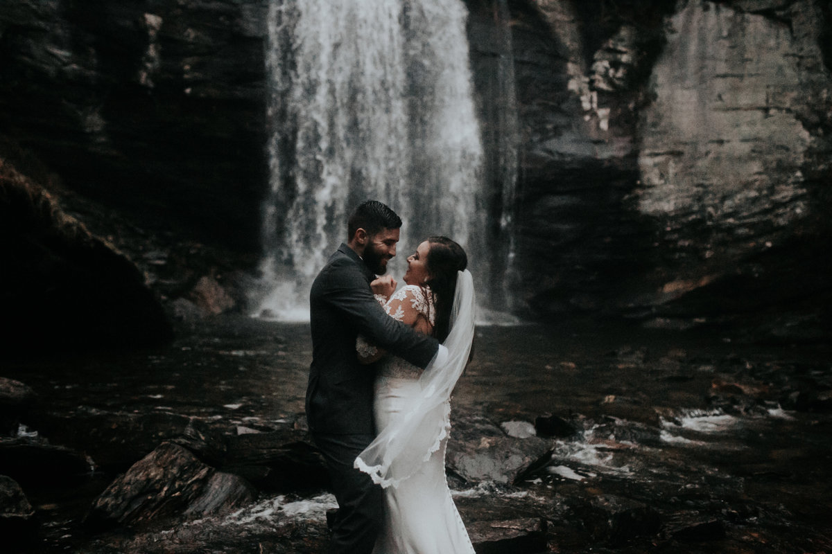 Bride and groom laughing at Looking Glass Falls in North Carolina